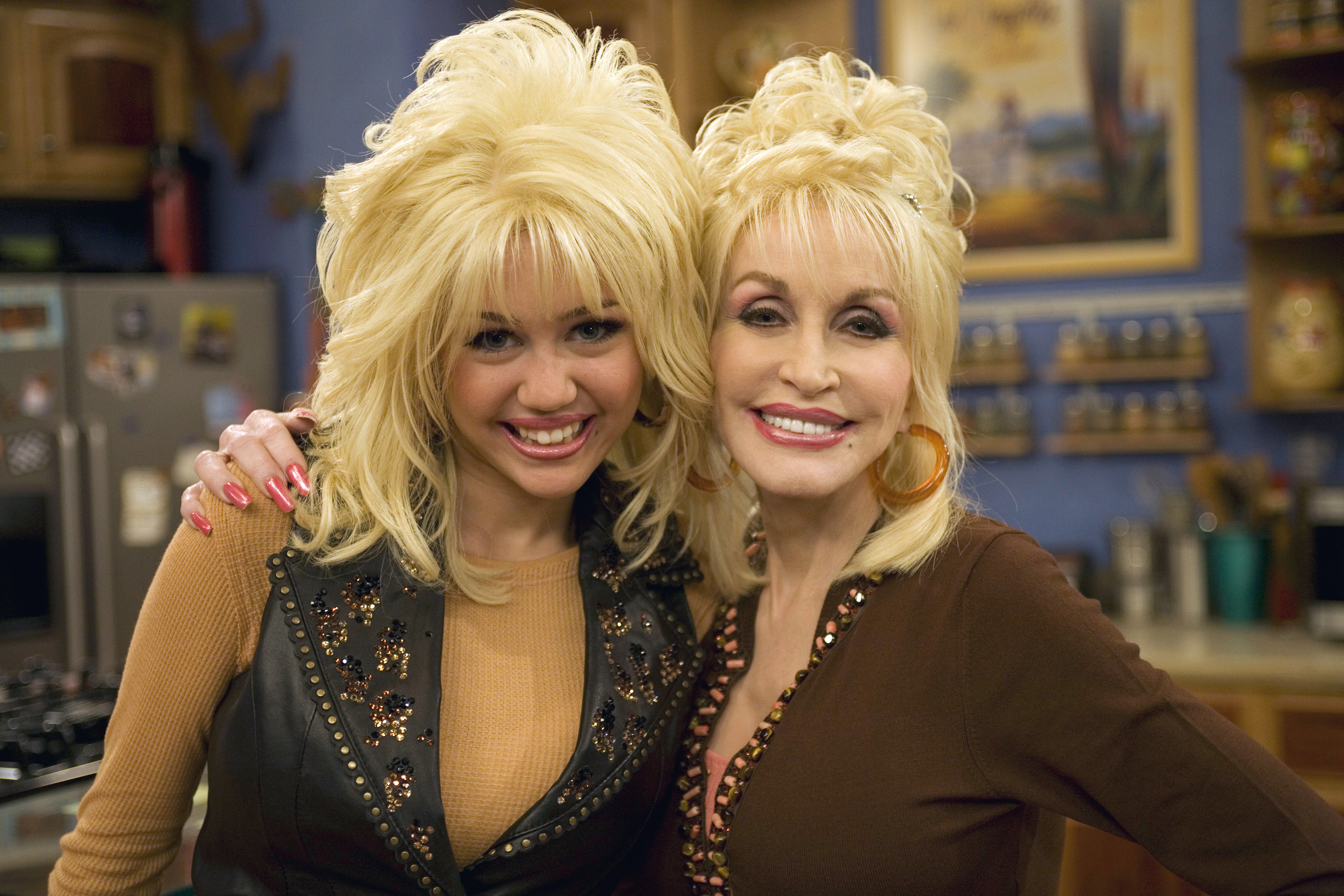 Miley Cyrus and Dolly Parton posing together on the set of Hannah Montana.